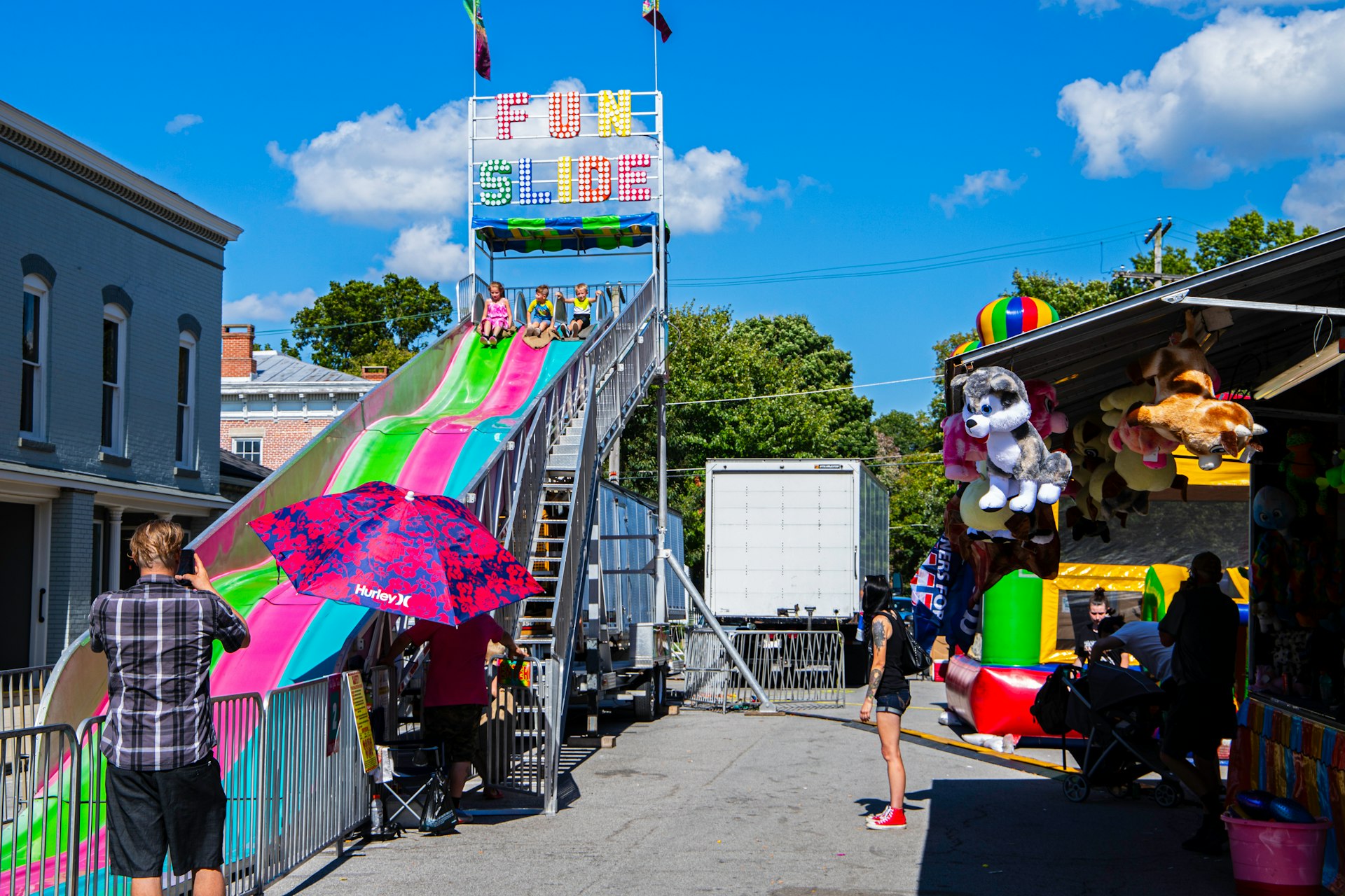 a person standing on a street next to a carnival ride