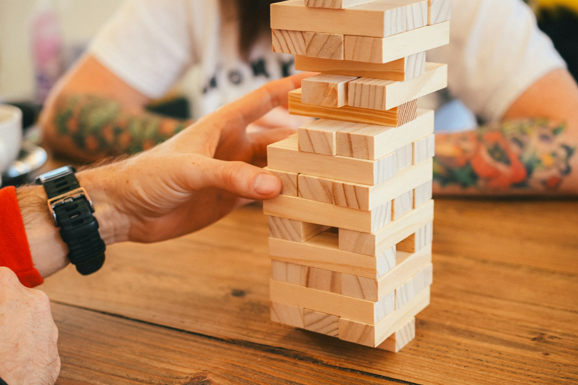 a person playing with a wooden block tower