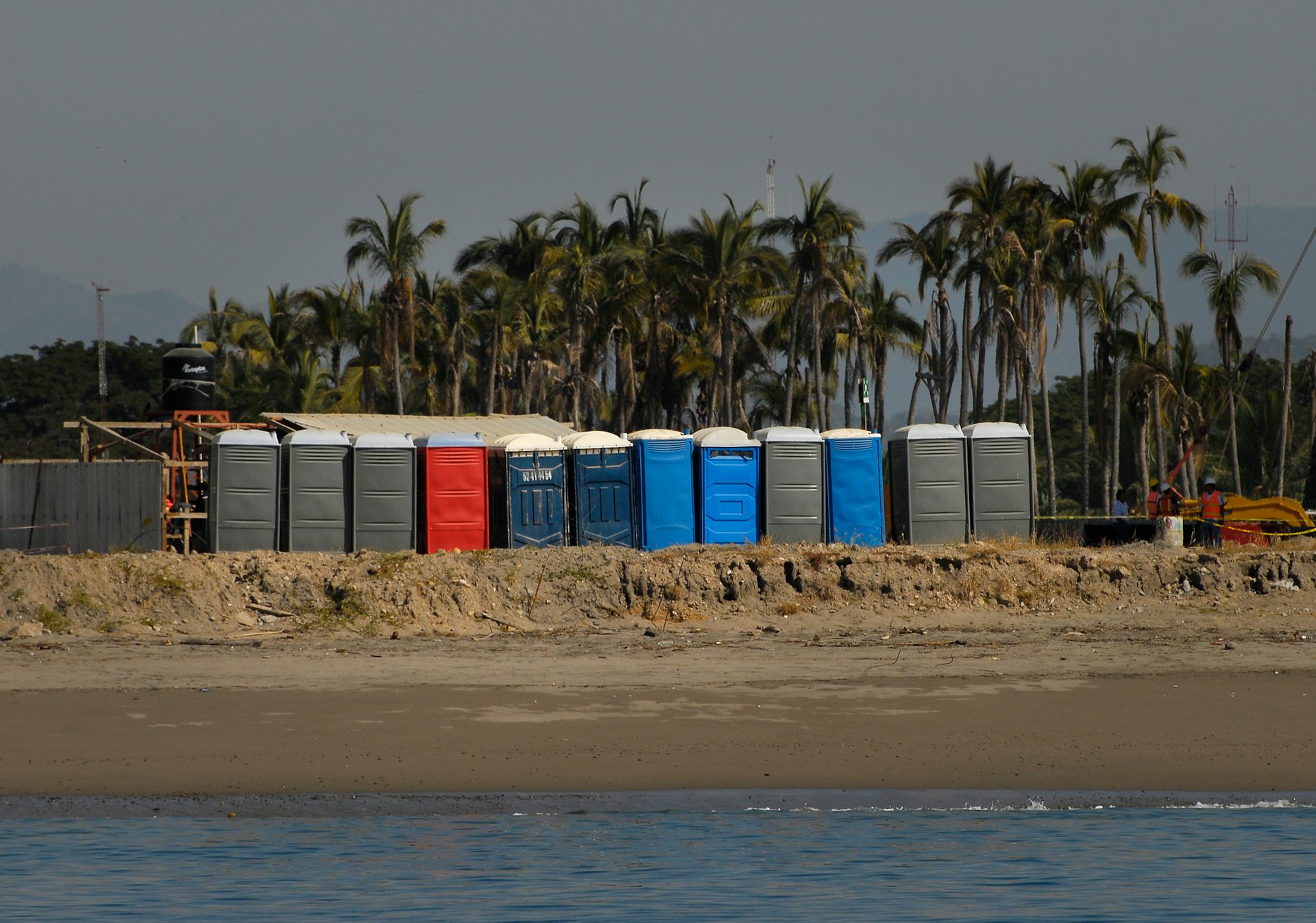 A row of beach huts sitting on top of a sandy beach
